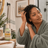 Woman with short wet curly hair holding Yazie Conditioner by Yene Hair during her wash-day routine
