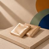 Folded Yene Hair satin pillowcases displayed on a warm neutral surface
