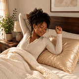 Woman relaxing in bed on a Yene Hair satin pillowcase during her nighttime hair-care routine