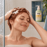 Woman with short red curly hair washing with Yazie Shampoo by Yene Hair in the shower