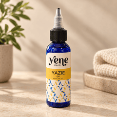 Yazie Hair Oil by Yene Hair in a cobalt blue bottle on a warm neutral background