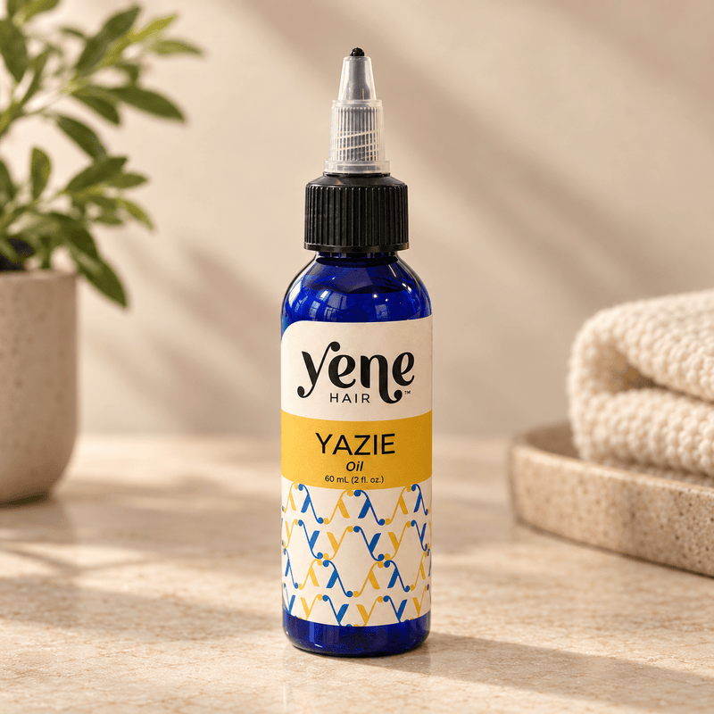 Yazie Hair Oil by Yene Hair in a cobalt blue bottle on a warm neutral background